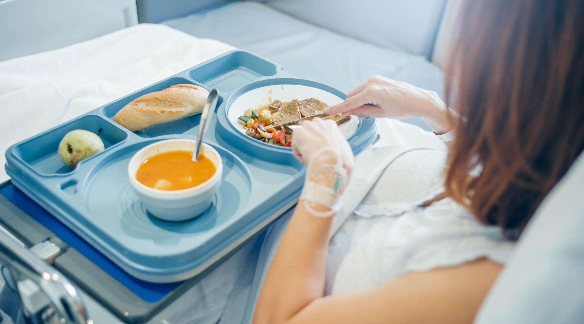 Sick woman in hospital getting food