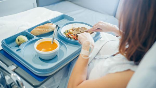 Sick woman in hospital getting food