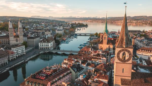 Panoramic aerial view of Zurich’s old town, the Limmat River and Lake Zurich, with the Alps in the background.