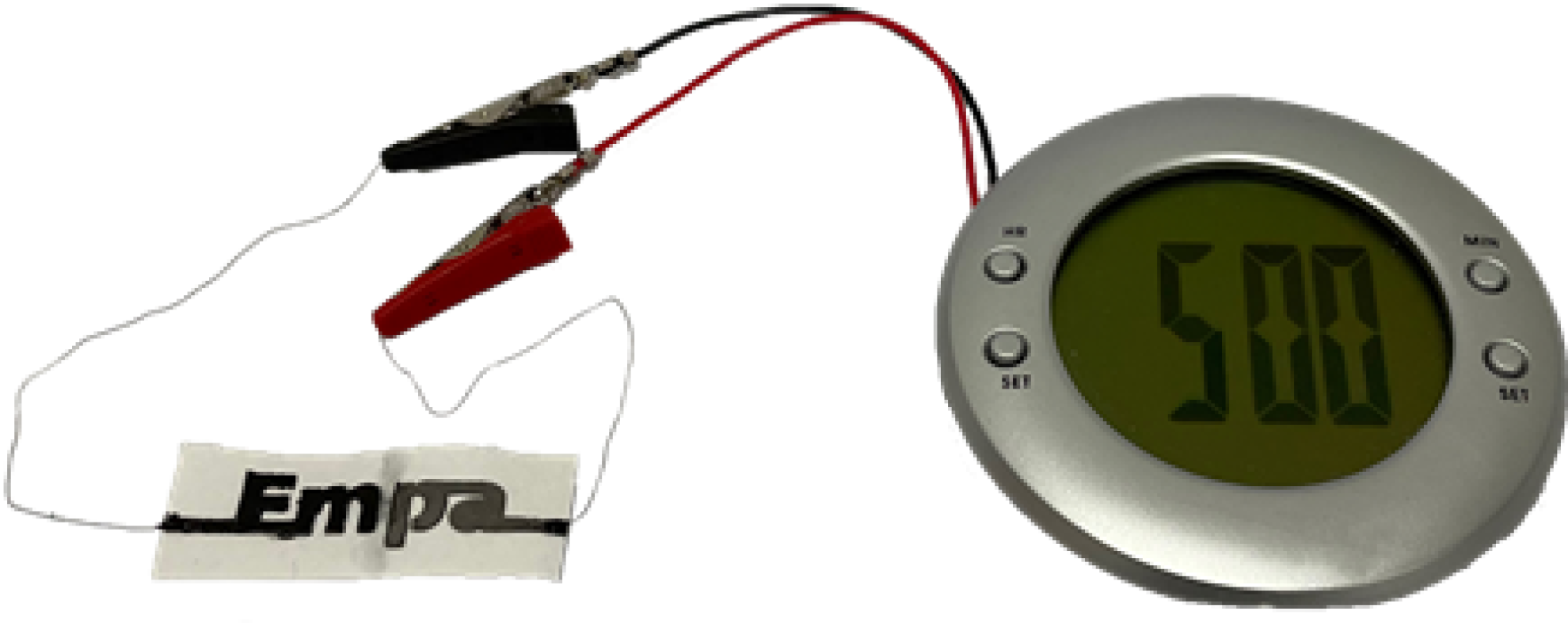 The paper battery can run low-power electronics such as the liquid crystal display (LCD) alarm clock connected to the battery. Source: Empa